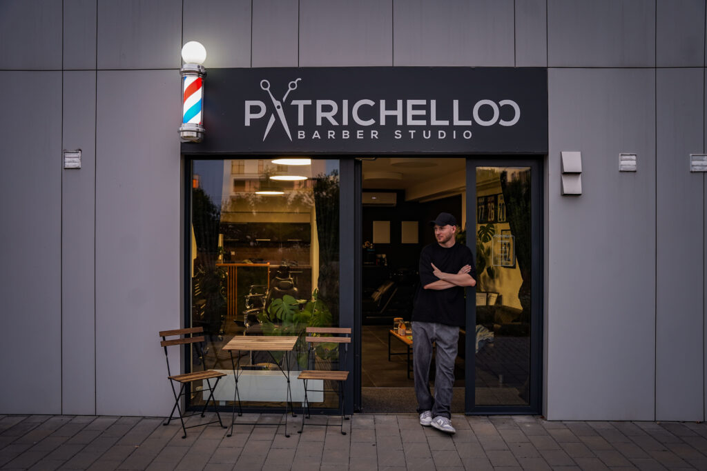 Patrik Bátovský stojí ve dveřích Patrichelloo Barber Studio na Rokycanově ulici