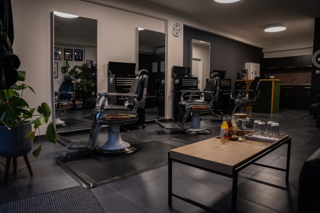Interiér Patrichelloo Barber Studio — barberské křeslo, zrcadla a tlumené osvětlení